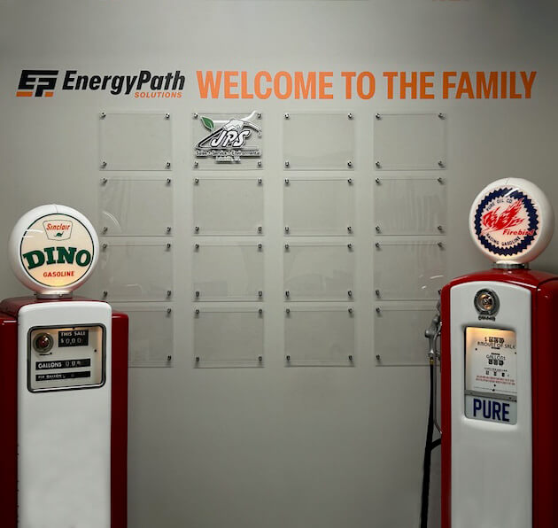 Photo of wall at EPS office proudly showing off the company they have acquired with headline "Welcome to the Family"